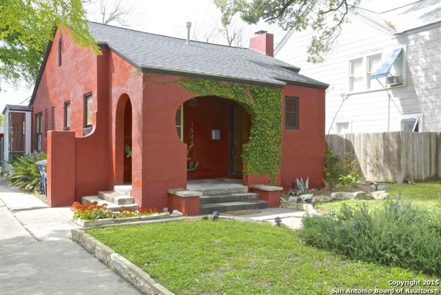 This is an example of a small and red mediterranean bungalow render house exterior in Austin.