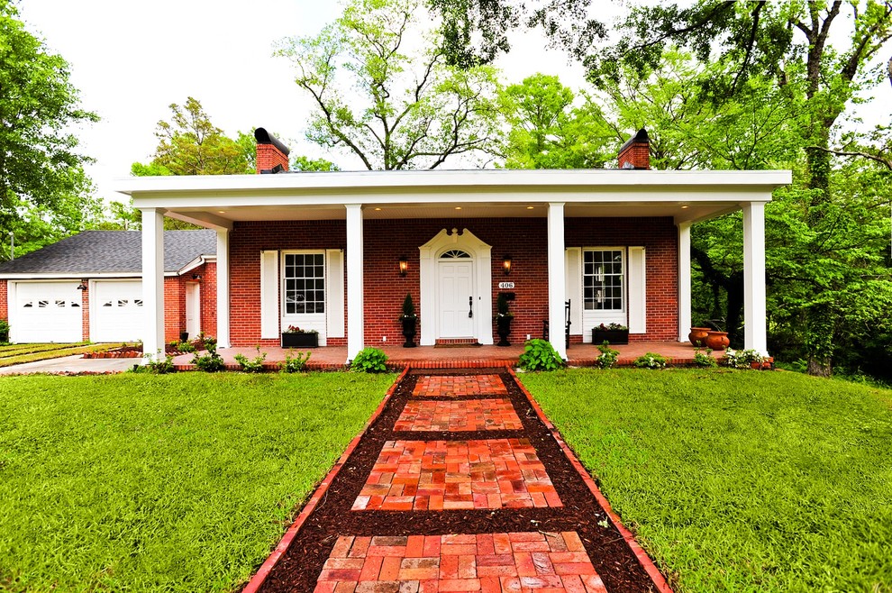 Inspiration pour une façade de maison rouge traditionnelle en brique de taille moyenne et de plain-pied avec un toit plat.