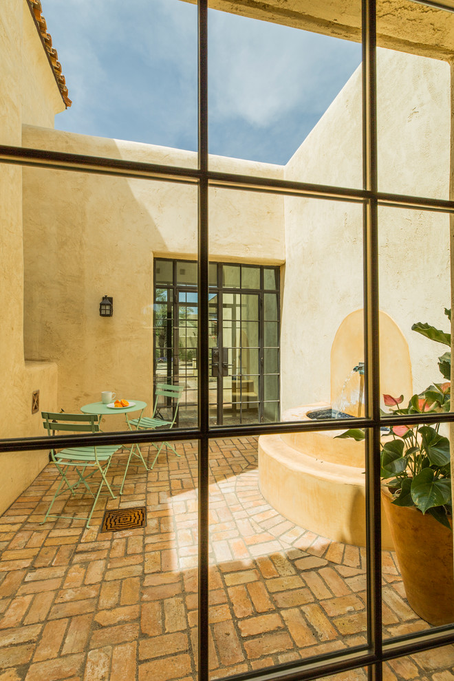Imagen de fachada de casa beige de estilo americano extra grande de dos plantas con revestimiento de adobe y tejado plano