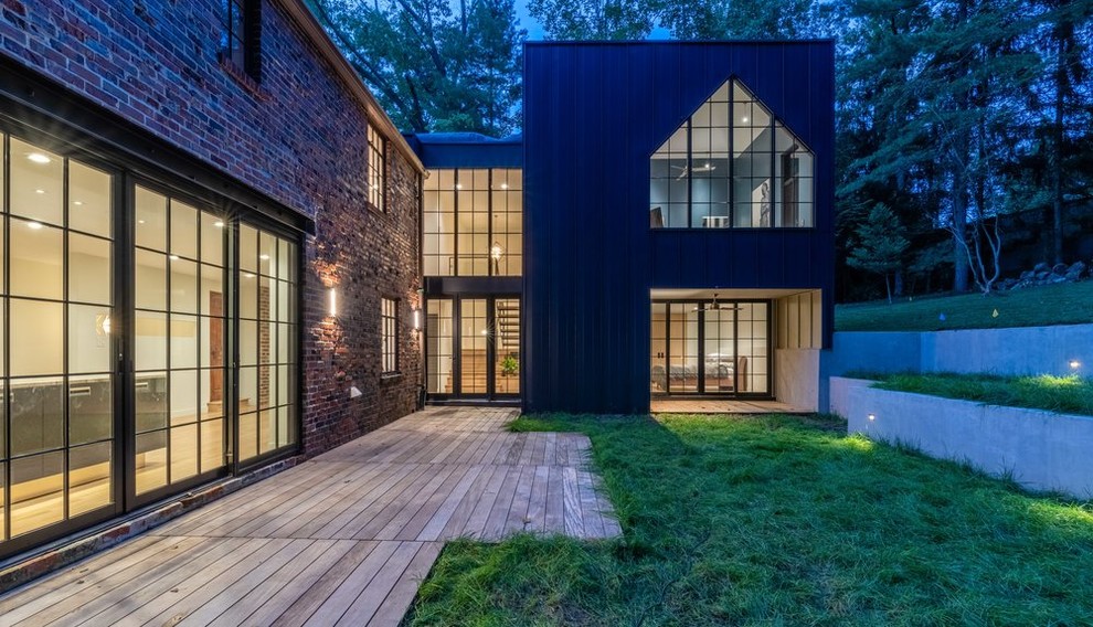 This is an example of a medium sized and blue eclectic two floor detached house in DC Metro with metal cladding, a flat roof and a mixed material roof.