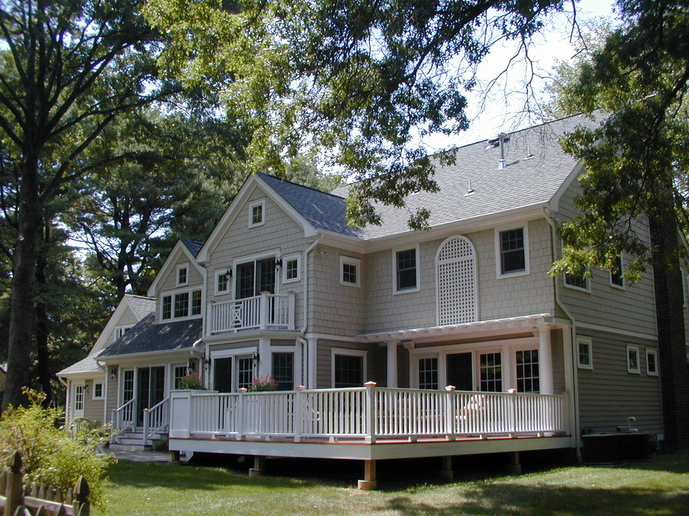 Idée de décoration pour une grande façade de maison grise tradition en bois à un étage avec un toit à deux pans.