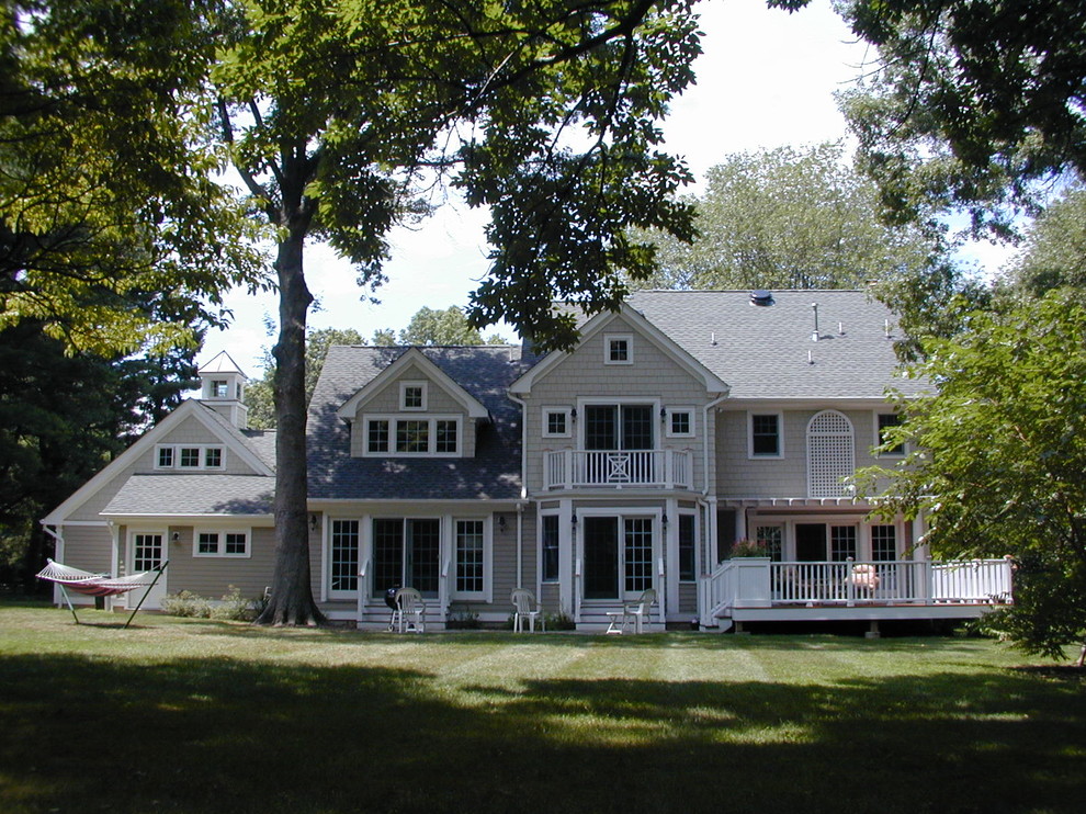 Réalisation d'une grande façade de maison grise tradition en bois à un étage avec un toit à deux pans.