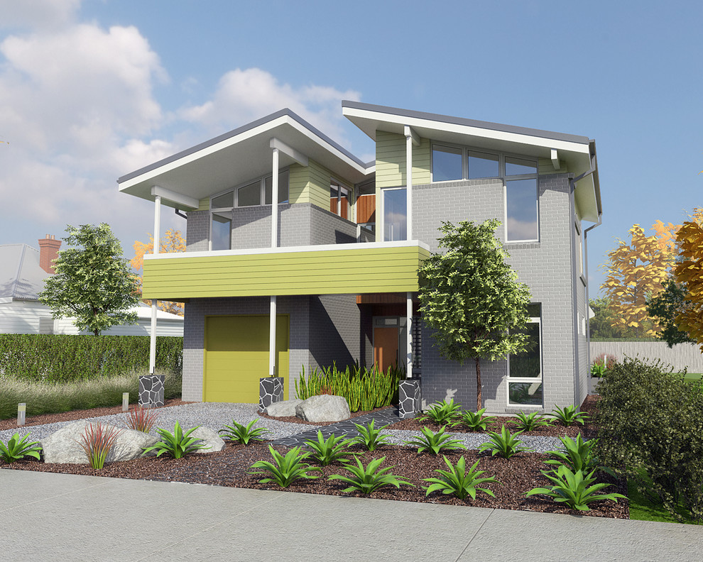 Idées déco pour une façade de maison grise rétro en brique de taille moyenne et à un étage avec un toit à croupette.