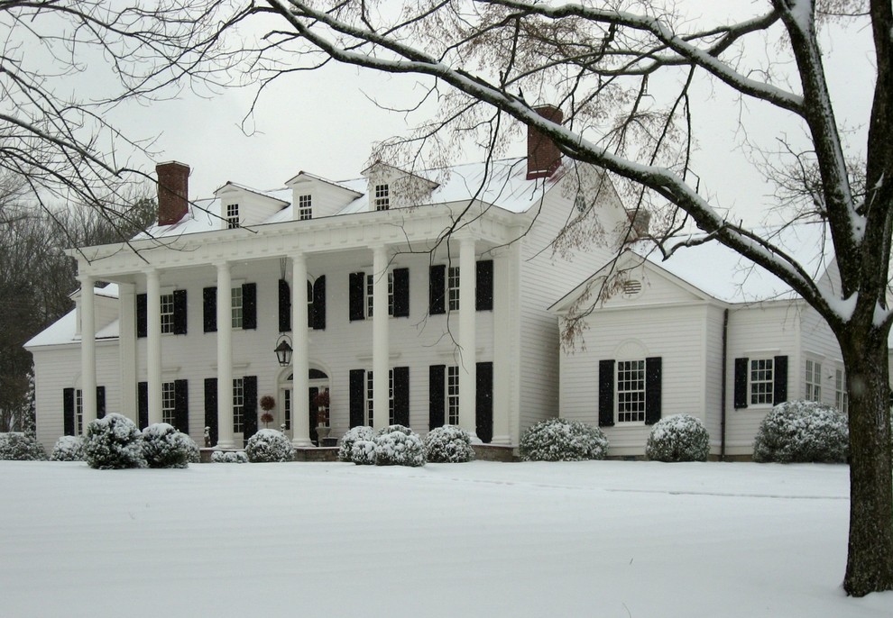 Photo of a large traditional house exterior in Nashville with three floors and wood cladding.