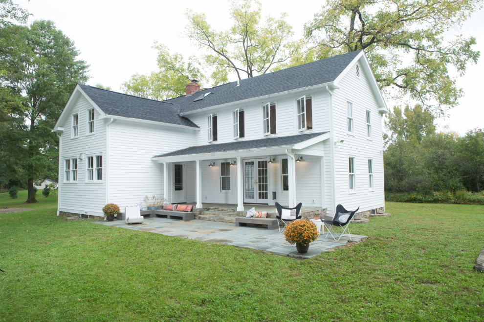 This is an example of a white country two floor detached house in New York with a shingle roof and a pitched roof.