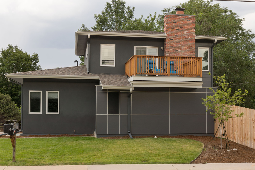 Cette image montre une façade de maison grise vintage en panneau de béton fibré de taille moyenne et à un étage avec un toit à deux pans.