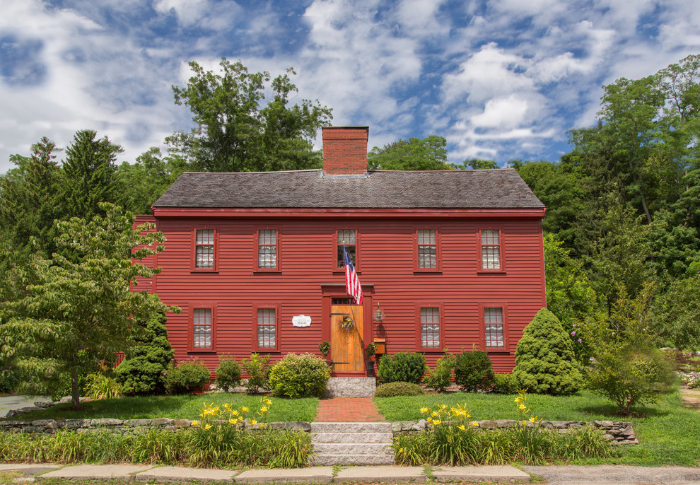 Exemple d'une façade de maison rouge chic en bois à un étage avec un toit à deux pans.