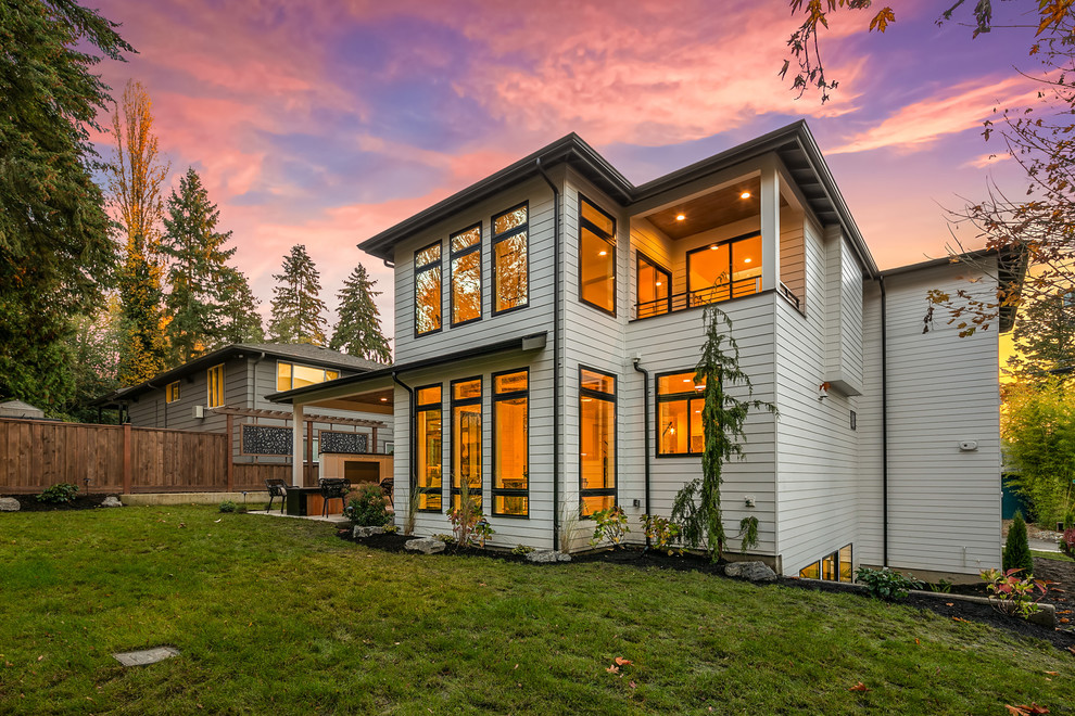 Large contemporary white three-story wood exterior home idea in Seattle