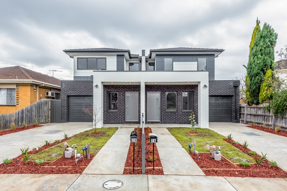 Diseño de fachada de casa bifamiliar gris y gris contemporánea de dos plantas con revestimiento de ladrillo y tejado a cuatro aguas