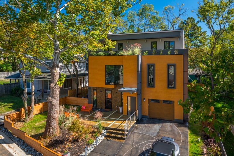 Пример оригинального дизайна: большой, двухэтажный, оранжевый дом в современном стиле с облицовкой из винила и плоской крышей