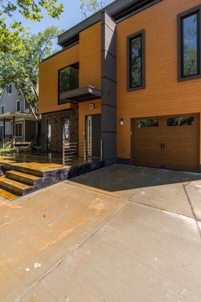 Idées déco pour une grande façade de maison jaune contemporaine à un étage avec un revêtement en vinyle et un toit plat.