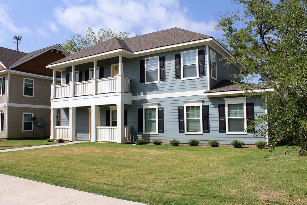 Пример оригинального дизайна: двухэтажный, синий дом в классическом стиле с облицовкой из ЦСП и двускатной крышей