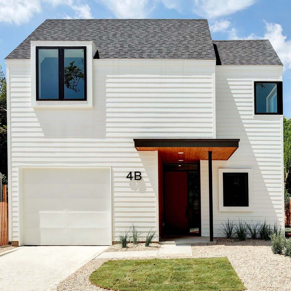 Aménagement d'une petite façade de maison blanche moderne en panneau de béton fibré à un étage avec un toit à deux pans et un toit en shingle.