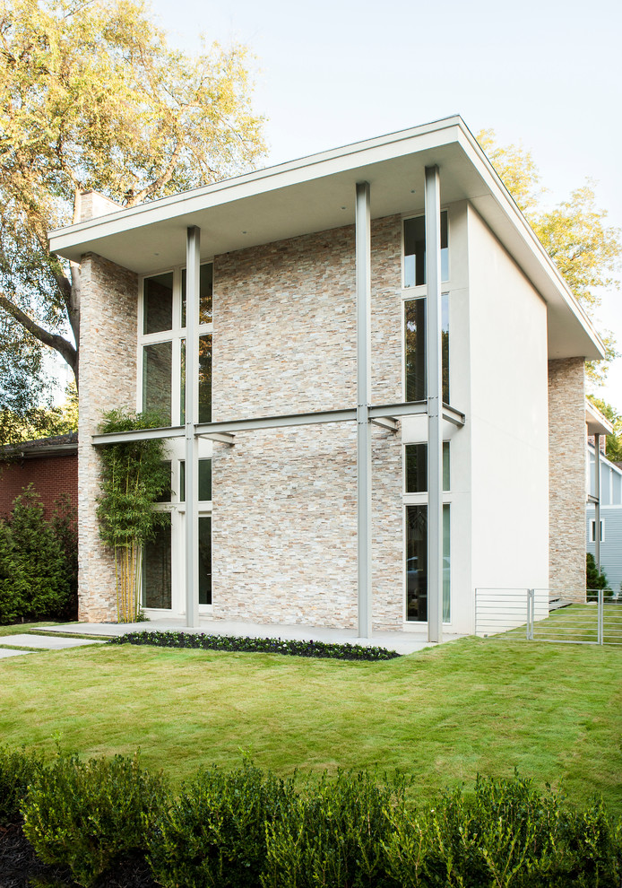Diseño de fachada contemporánea de dos plantas con revestimientos combinados