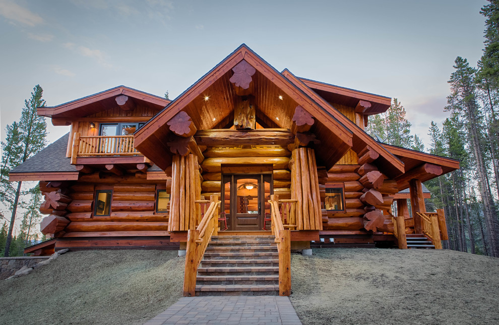 Photo of a rustic two floor house exterior in Denver with wood cladding.