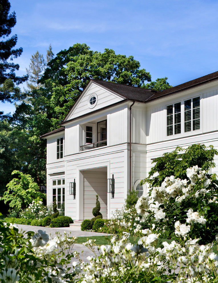 Immagine della facciata di una casa bianca classica a due piani con tetto a capanna