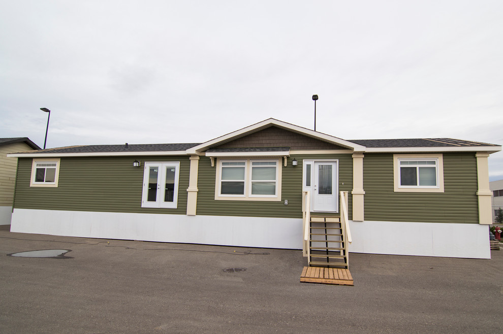 This is an example of a large and green contemporary bungalow house exterior in Calgary with vinyl cladding.