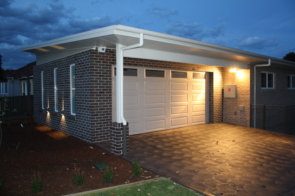 Inspiration for a medium sized and gey contemporary bungalow brick house exterior in Newcastle - Maitland with a flat roof.