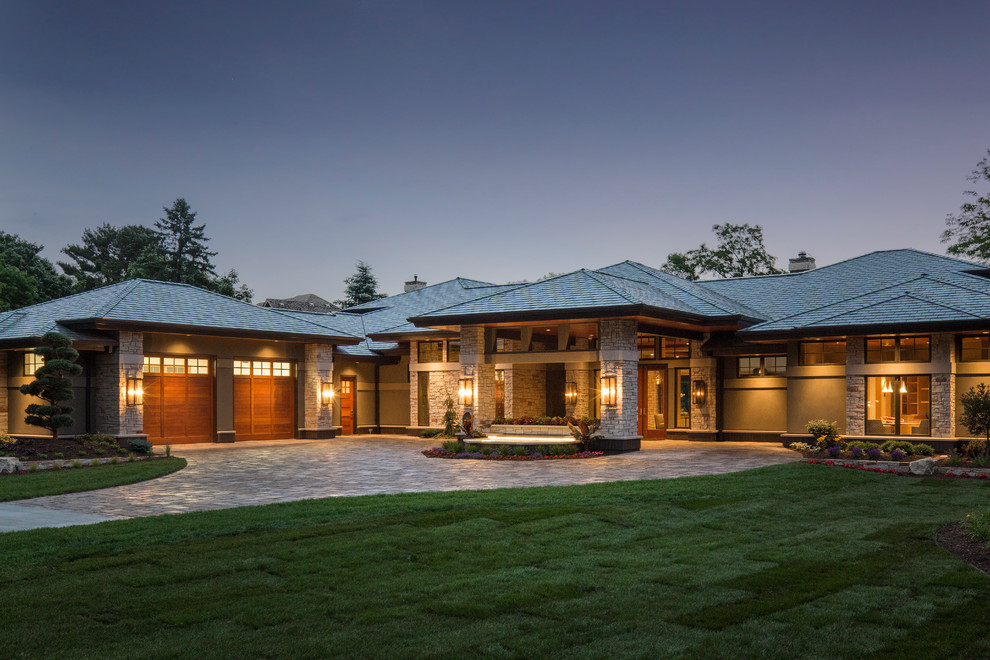 Inspiration for an expansive and beige contemporary two floor house exterior in Minneapolis with stone cladding and a hip roof.