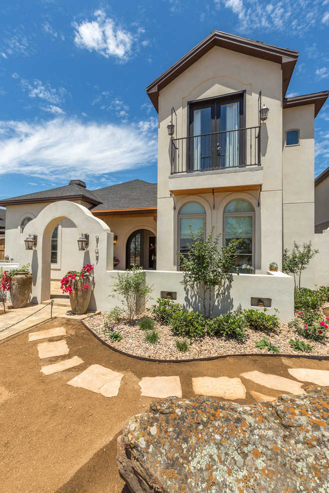 Example of a tuscan beige two-story stucco exterior home design in Austin