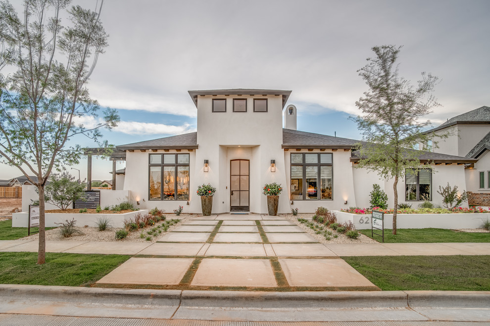 Inspiration for a large mediterranean white one-story stucco exterior home remodel in Austin with a hip roof