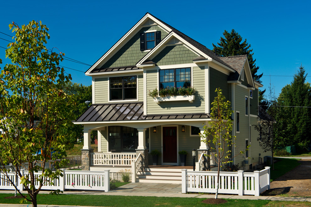 Immagine della facciata di una casa verde a tre piani con rivestimenti misti