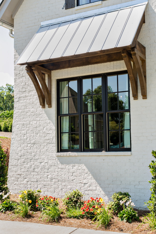 Diseño de fachada blanca clásica renovada grande de dos plantas con revestimiento de ladrillo y tejado a dos aguas