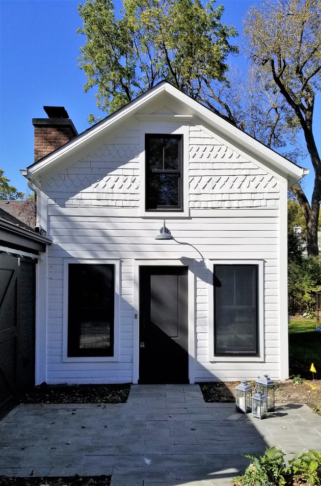 Einstöckiges, Kleines Landhaus Einfamilienhaus mit schwarzer Fassadenfarbe, Satteldach, Schindeldach und Vinylfassade in Chicago