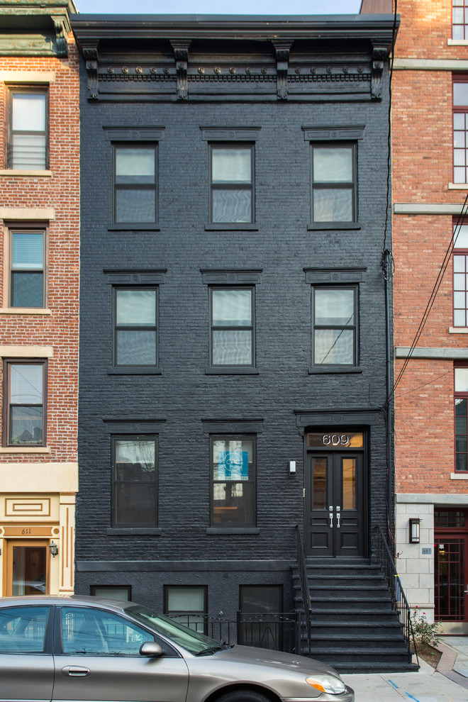 Diseño de fachada de casa pareada negra moderna de tres plantas con revestimiento de ladrillo y tejado plano