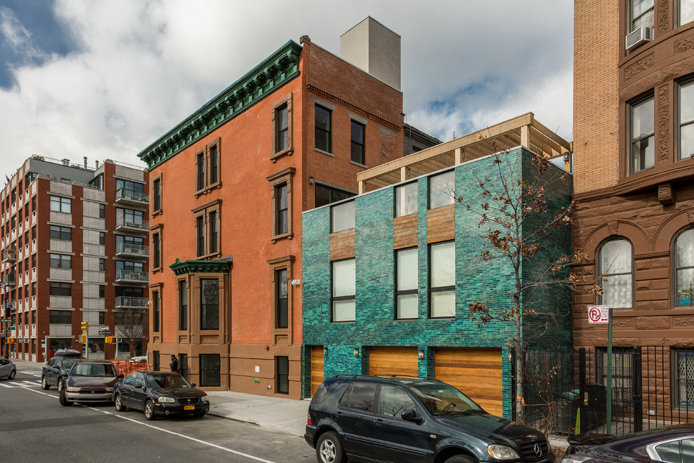 Example of a minimalist blue three-story brick exterior home design in New York