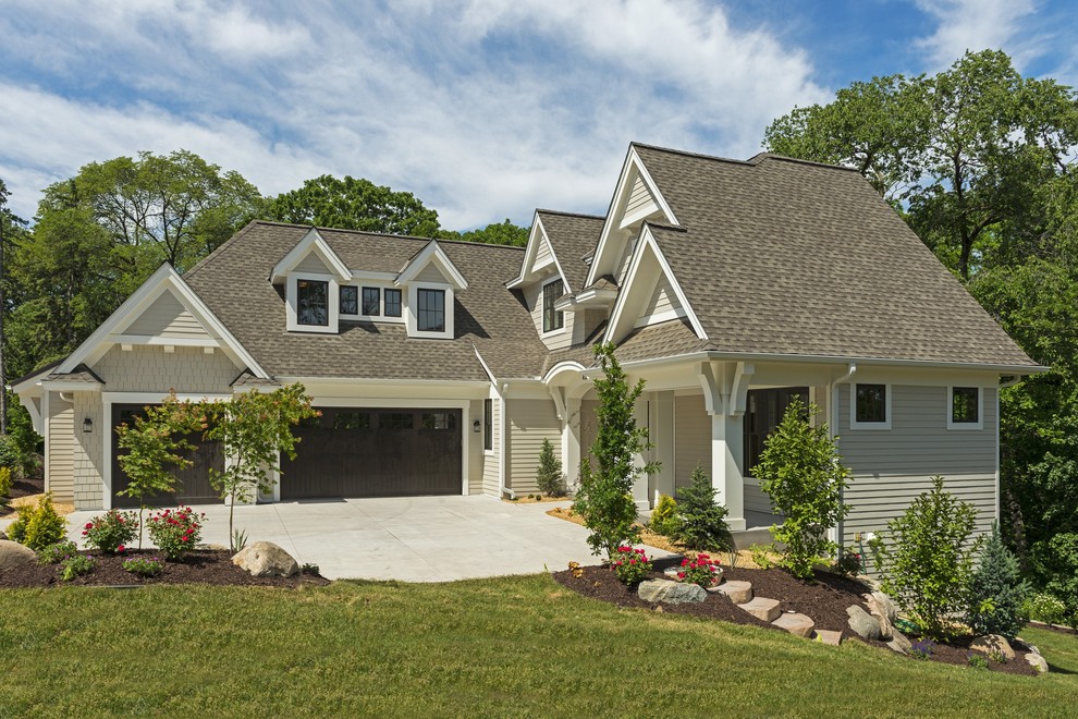 Imagen de fachada de casa beige costera grande con revestimientos combinados, tejado a dos aguas y tejado de teja de madera