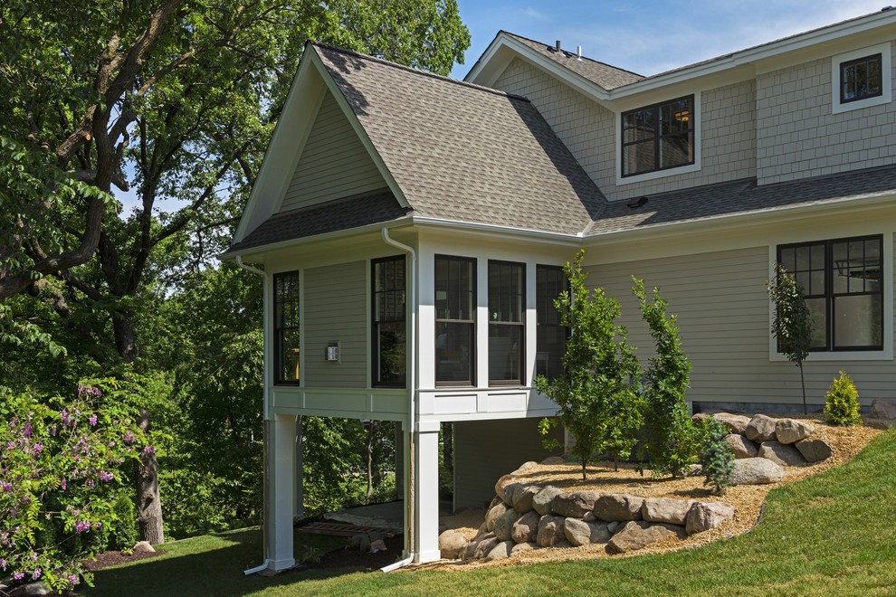 Diseño de fachada de casa beige costera grande con revestimientos combinados, tejado a dos aguas y tejado de teja de madera