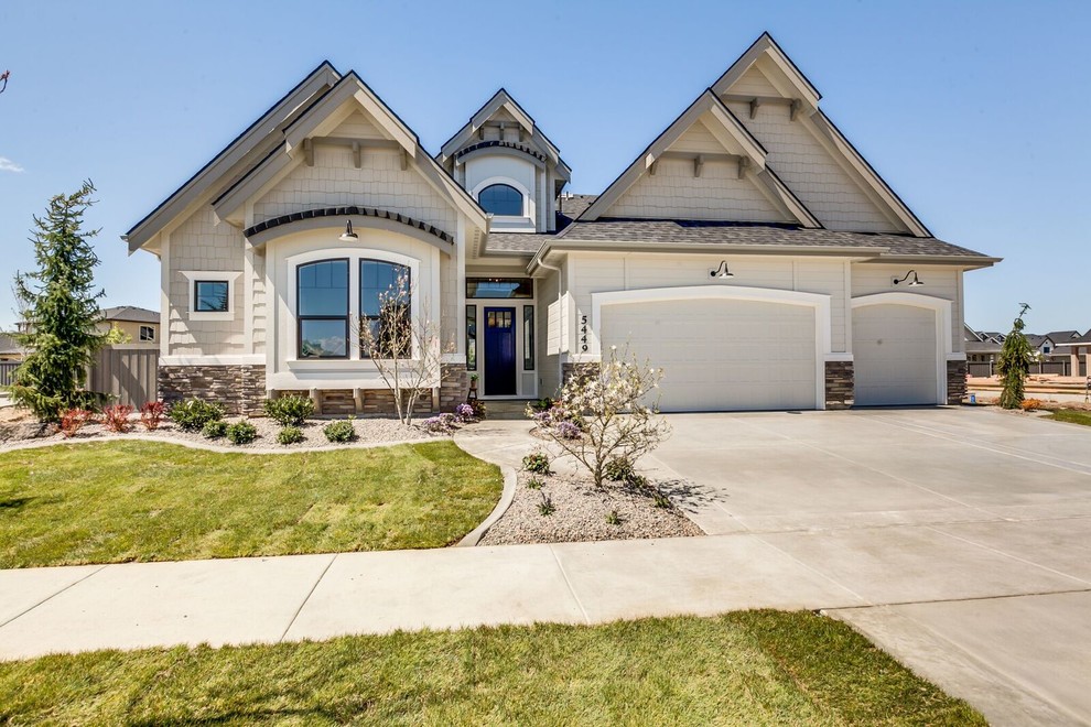 Example of a large transitional beige two-story wood exterior home design in Boise with a shingle roof