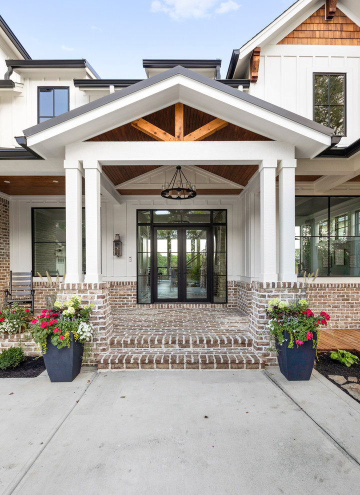 Example of a huge farmhouse white two-story brick exterior home design in Indianapolis with a metal roof