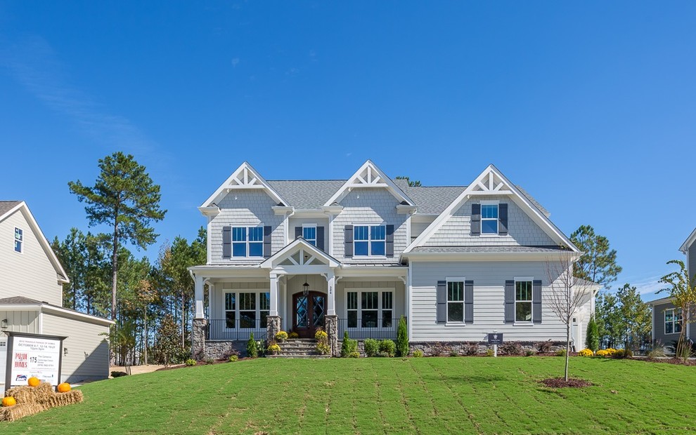 Large and gey farmhouse detached house in Raleigh with three floors, mixed cladding, a pitched roof and a mixed material roof.