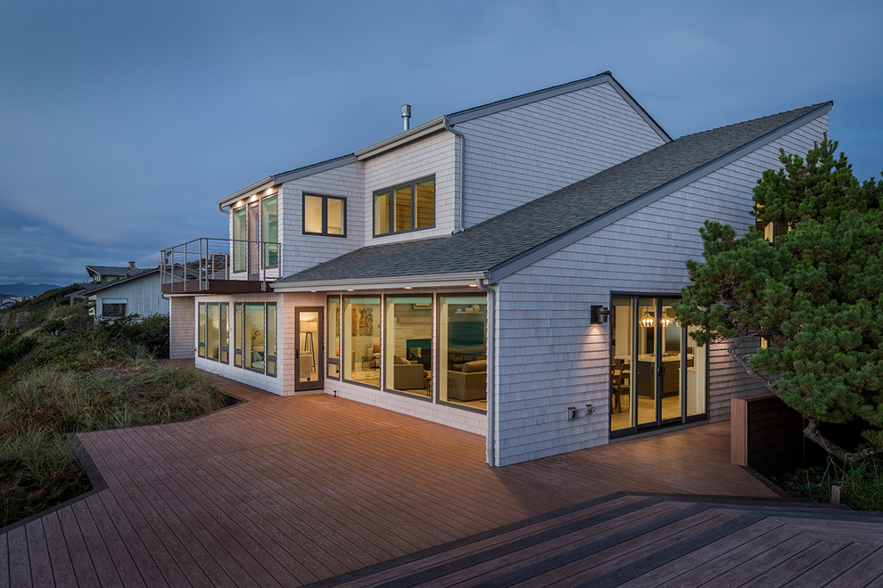 Ejemplo de fachada de casa gris costera grande de dos plantas con revestimiento de madera, tejado a dos aguas y tejado de teja de madera