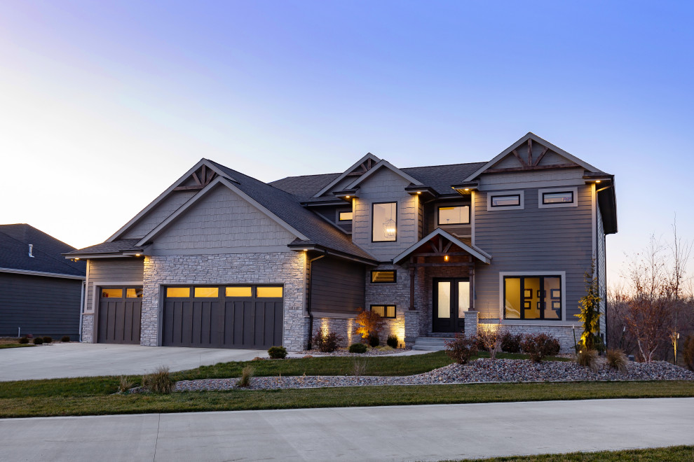 Cette image montre une grande façade de maison grise craftsman à un étage avec un revêtement mixte, un toit à deux pans et un toit en shingle.