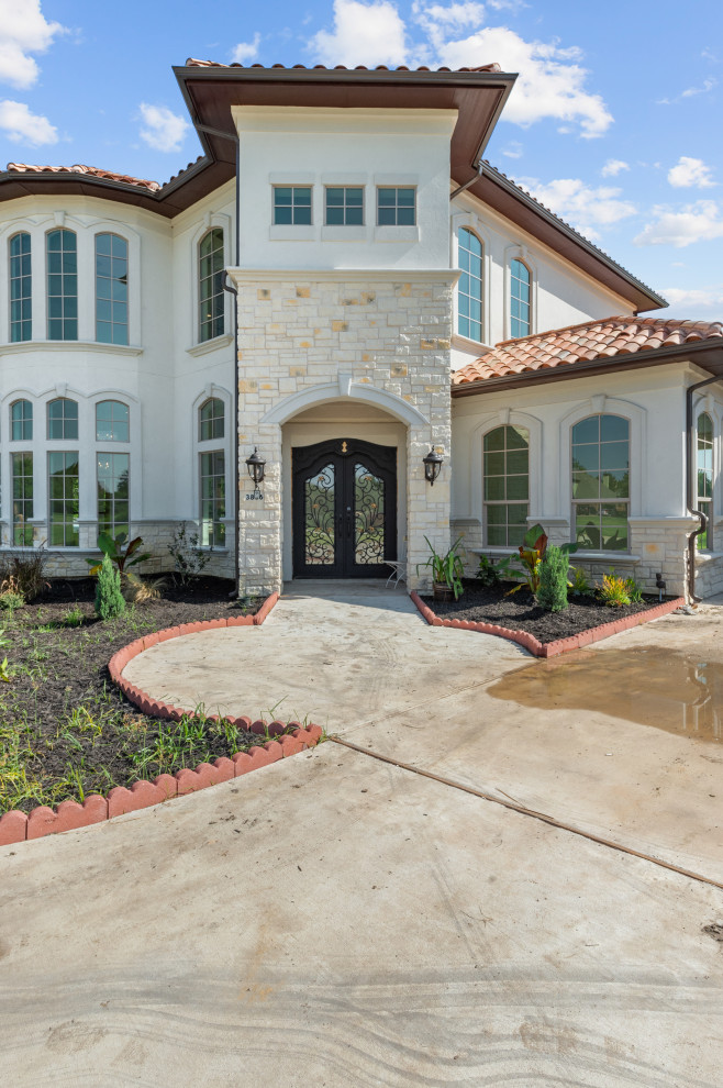 Inspiration for a huge mediterranean white two-story stucco exterior home remodel in Dallas with a tile roof