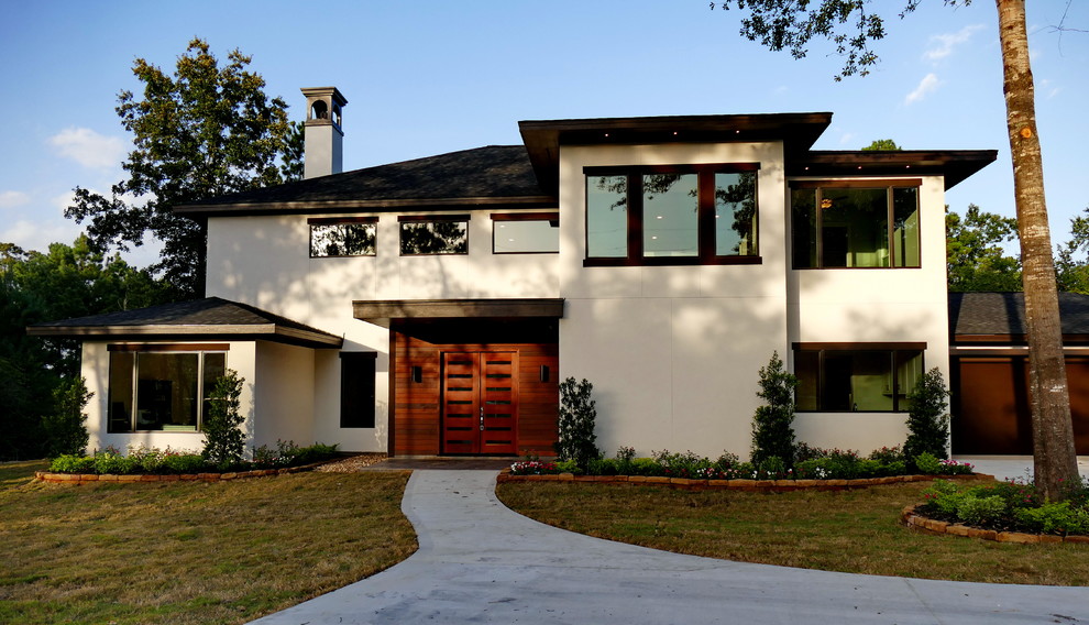 На фото: большой, двухэтажный, белый дом в современном стиле с облицовкой из цементной штукатурки и вальмовой крышей
