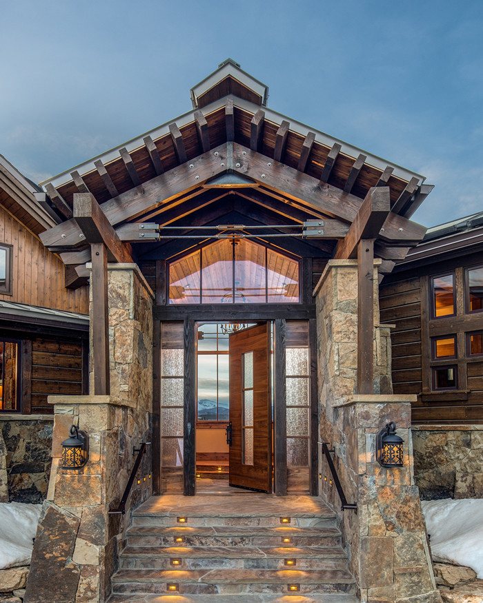 Large rustic brown two-story stone gable roof idea in Denver
