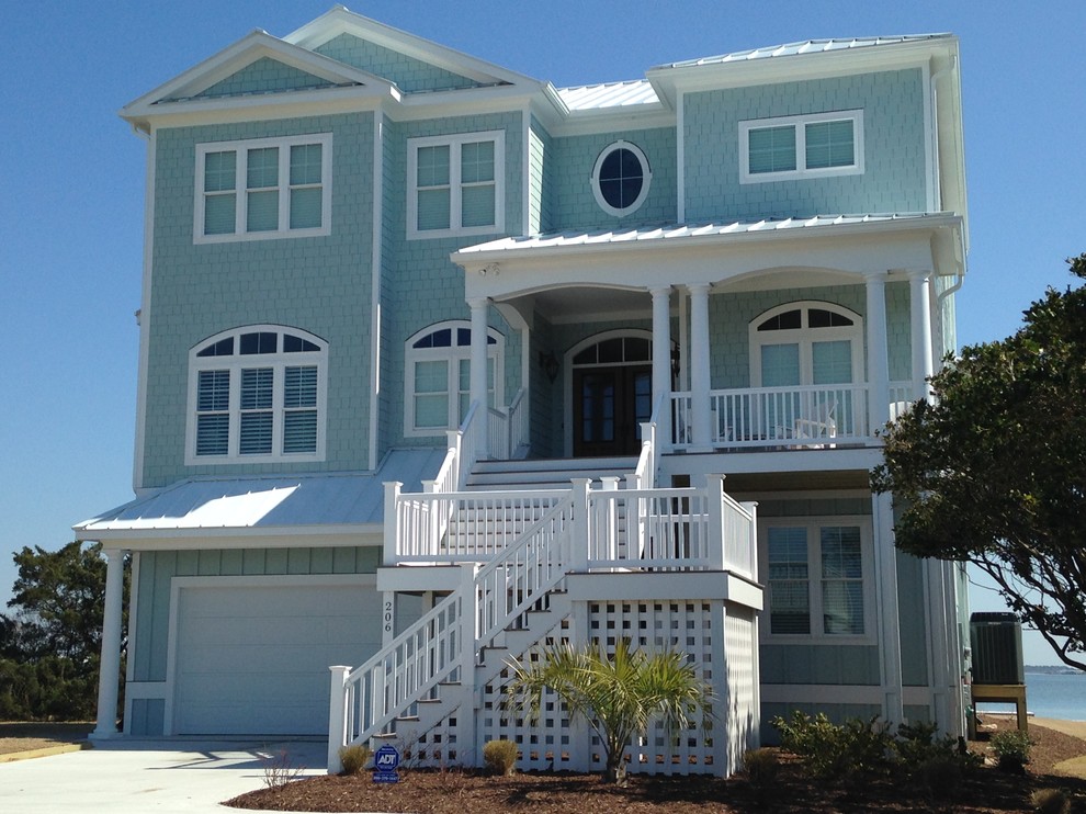 Cette image montre une grande façade de maison bleue marine en panneau de béton fibré à deux étages et plus avec un toit à deux pans.