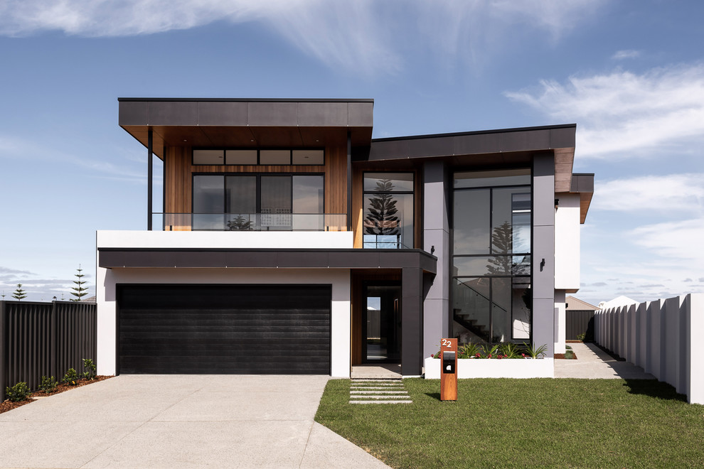 Imagen de fachada de casa multicolor moderna de dos plantas con revestimientos combinados y tejado a dos aguas