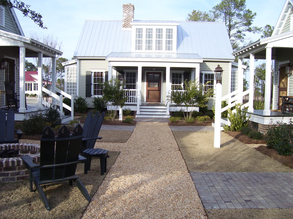 На фото: маленький, двухэтажный, серый дом в стиле кантри для на участке и в саду