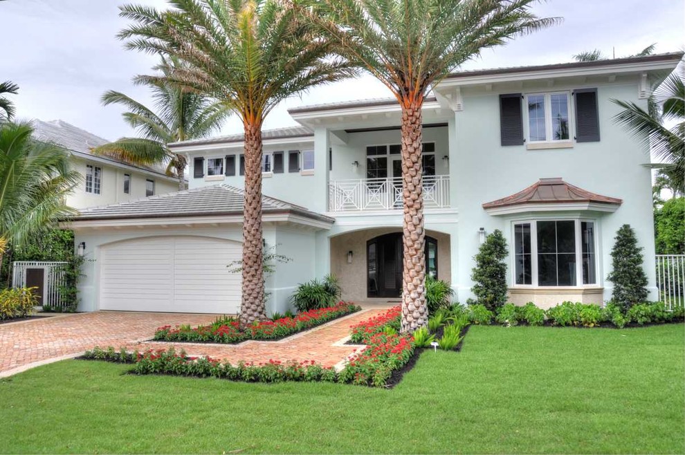 Diseño de fachada de casa azul tropical grande de dos plantas con revestimiento de estuco, tejado a cuatro aguas y tejado de teja de madera