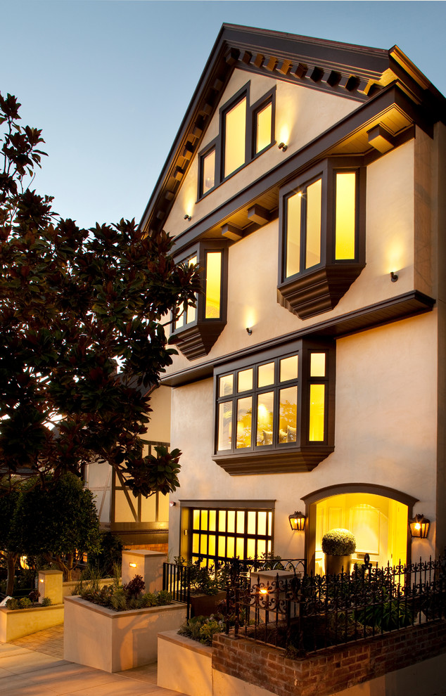 Immagine della facciata di una casa beige classica a tre piani