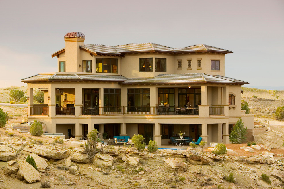 Стильный дизайн: большой, двухэтажный, коричневый частный загородный дом в средиземноморском стиле с комбинированной облицовкой, вальмовой крышей и крышей из гибкой черепицы - последний тренд