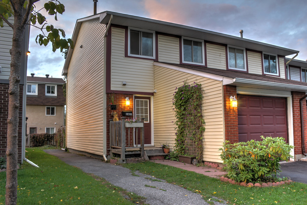 Exemple d'une façade de maison beige tendance de taille moyenne et à un étage avec un revêtement en vinyle.