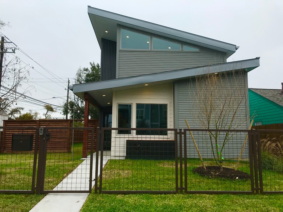 ヒューストンにある高級なコンテンポラリースタイルのおしゃれな家の外観 (混合材サイディング、緑の外壁、混合材屋根) の写真