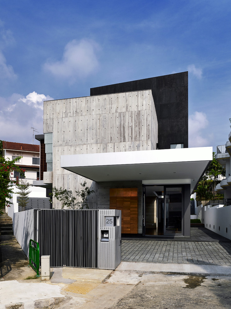 Contemporary house exterior in Singapore with three floors, mixed cladding and a flat roof.