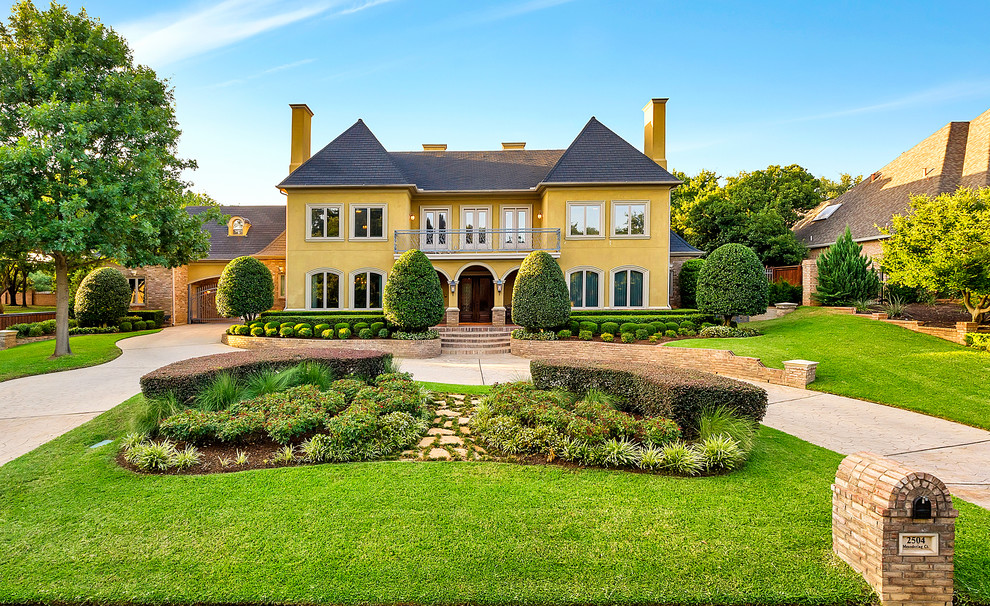 Example of a classic yellow two-story exterior home design in Dallas